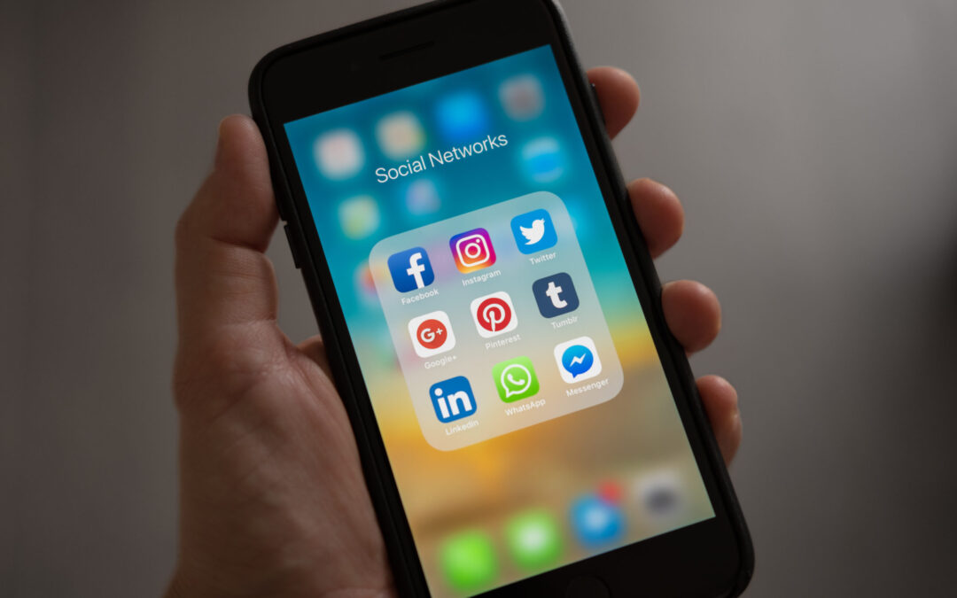 Social media strategy showing a smartphone with the social media icons in one folder